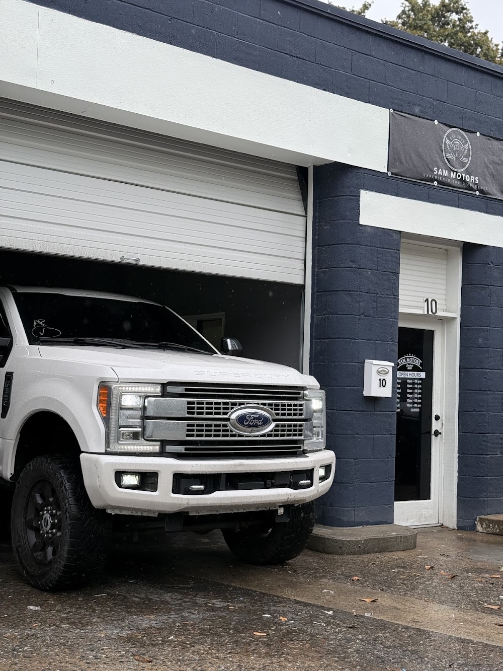 A white Ford truck photographed at the Sam Motors dealership